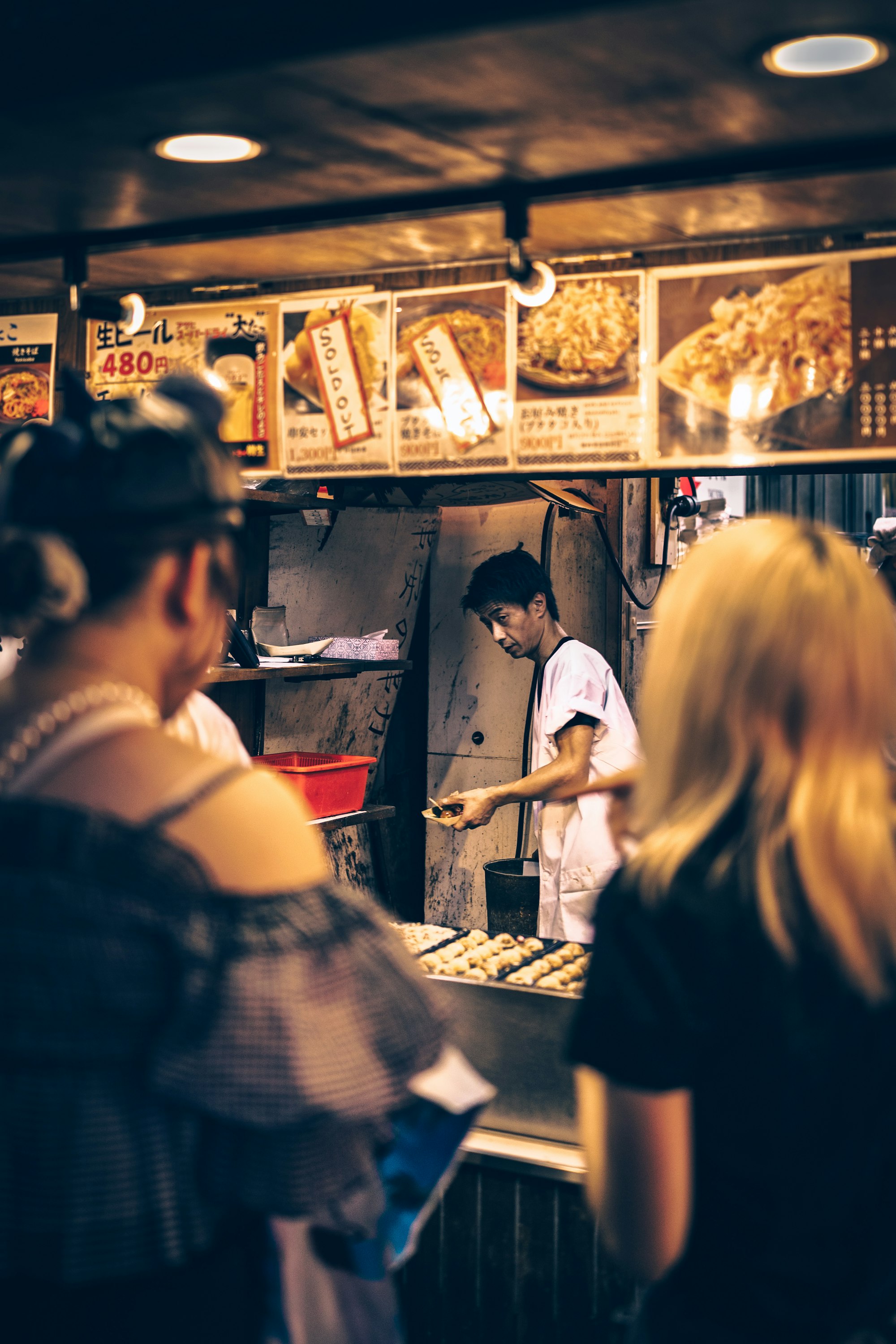 A street food vendor preparing food at a busy market stall